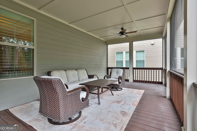 wooden deck with an outdoor living space and ceiling fan