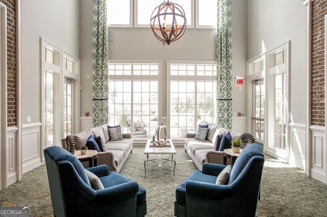 living room with plenty of natural light, carpet flooring, and a high ceiling