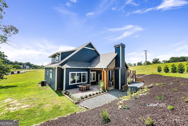 back of property featuring a patio, a rural view, and a yard