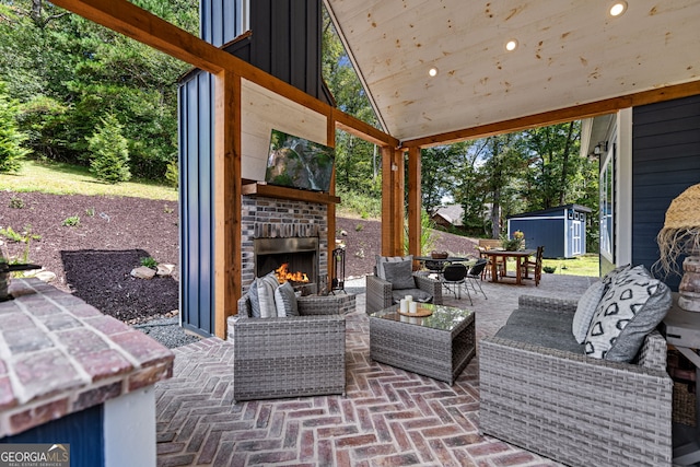 view of patio featuring a storage shed and an outdoor living space with a fireplace