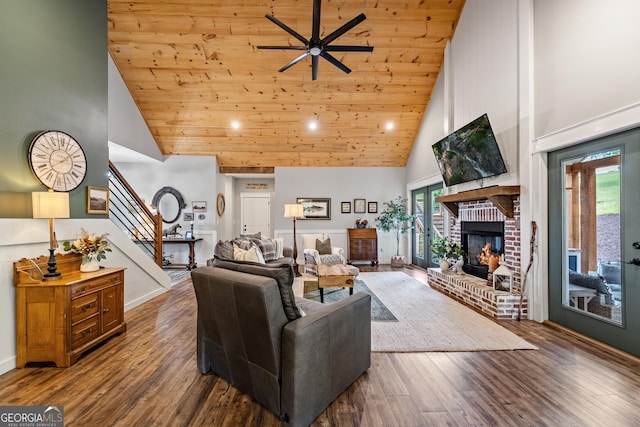 living room featuring wood ceiling, dark wood-type flooring, high vaulted ceiling, a fireplace, and ceiling fan