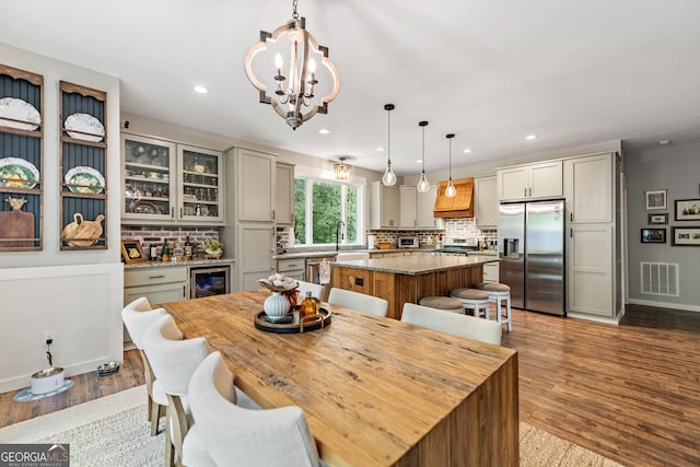 dining room featuring an inviting chandelier, beverage cooler, light hardwood / wood-style floors, and sink