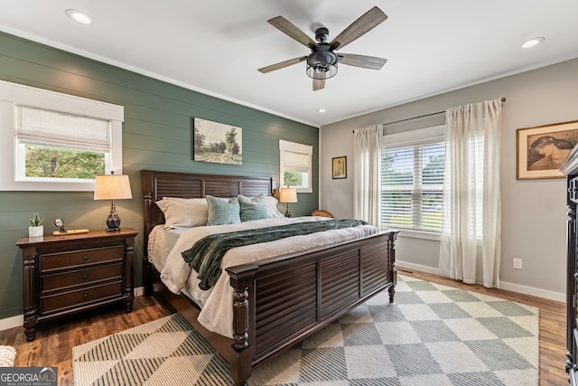 bedroom featuring multiple windows, wood-type flooring, and ceiling fan