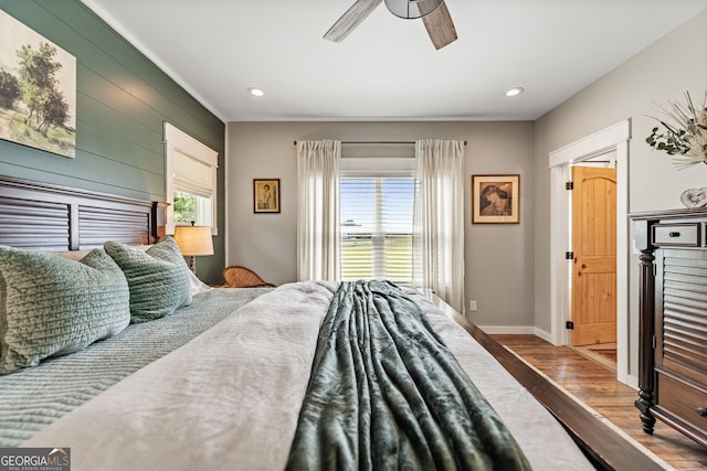 bedroom featuring multiple windows, ceiling fan, and hardwood / wood-style flooring