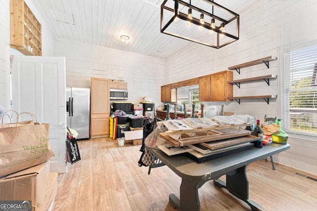 interior space with wood ceiling, light wood-type flooring, wood walls, and an inviting chandelier