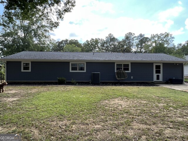 view of front of home with central air condition unit and a front lawn