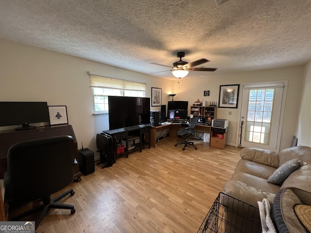 office area with a textured ceiling, wood finished floors, a ceiling fan, and a wealth of natural light