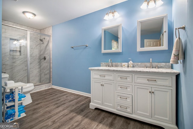 bathroom featuring an enclosed shower, vanity, toilet, and wood-type flooring