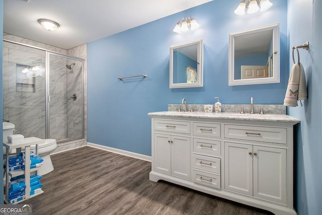 bathroom with walk in shower, hardwood / wood-style floors, vanity, and toilet