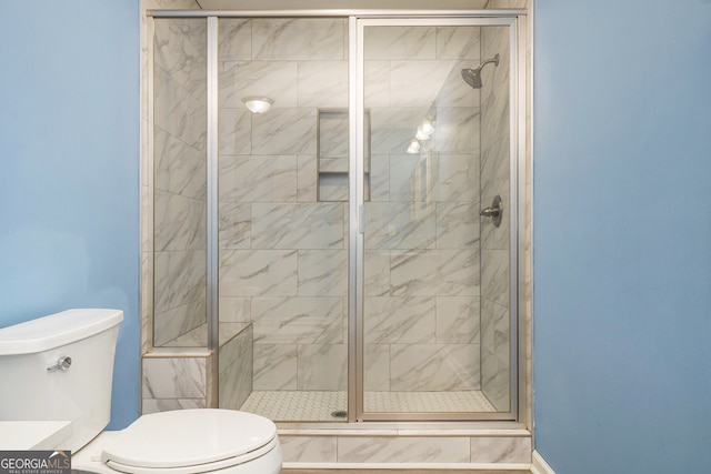 bathroom with a shower with shower door, vanity, and toilet