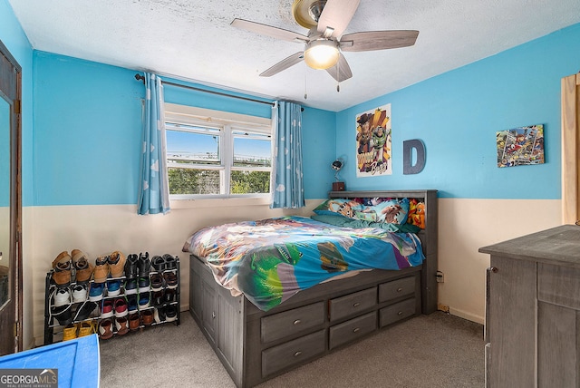 carpeted bedroom with a textured ceiling and ceiling fan