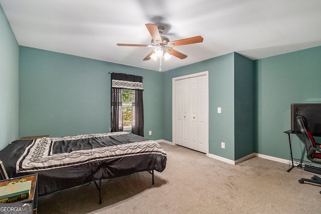 carpeted bedroom with ceiling fan and a closet