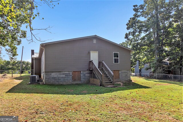 315 Watts Rd, Hiram, GA 30141 - rear view of house featuring central air condition unit, a lawn, and fence
