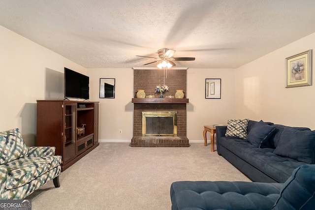 living room with a brick fireplace, a textured ceiling, carpet flooring, and ceiling fan