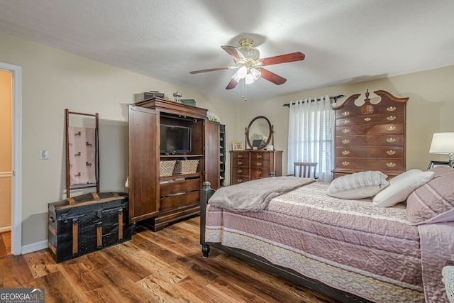 bedroom featuring ceiling fan, a textured ceiling, and dark hardwood / wood-style floors