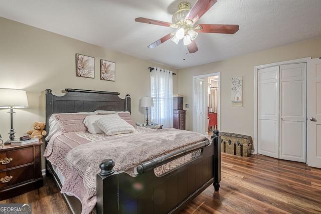 bedroom with a textured ceiling, dark hardwood / wood-style flooring, and ceiling fan