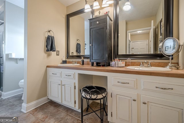 bathroom featuring tile patterned flooring, vanity, and toilet