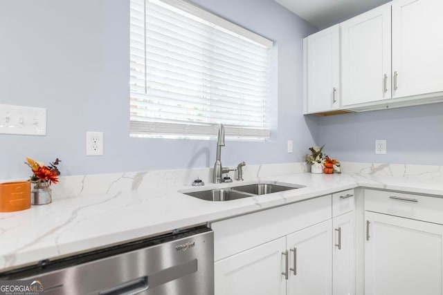 kitchen with light stone counters, sink, white cabinetry, and stainless steel dishwasher