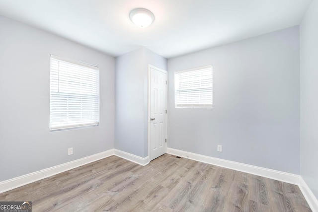 unfurnished room featuring light wood-type flooring and a wealth of natural light