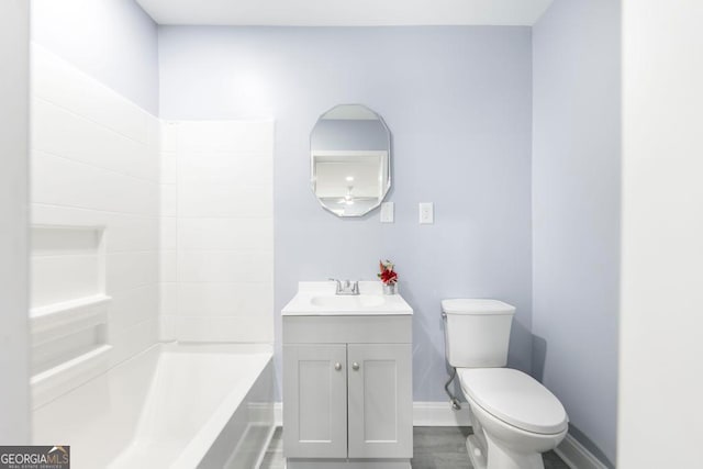 bathroom featuring toilet, vanity, and a tub