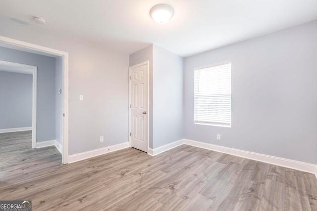 unfurnished bedroom featuring light hardwood / wood-style floors and a closet