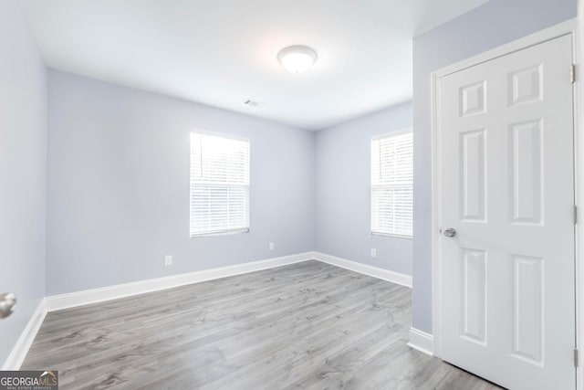 empty room with light hardwood / wood-style flooring