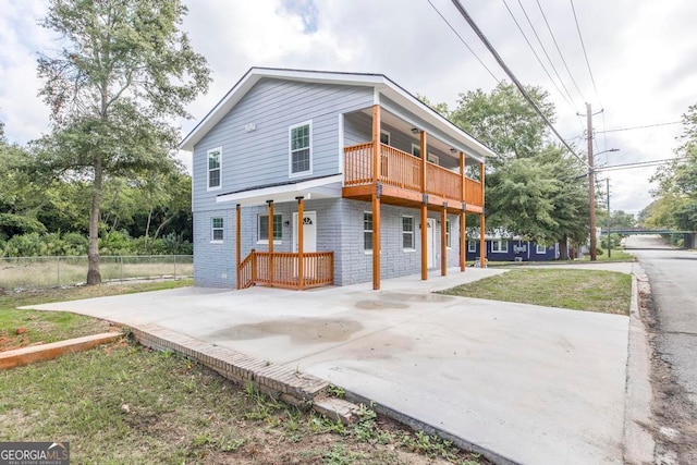 view of front of home with a balcony and a front lawn