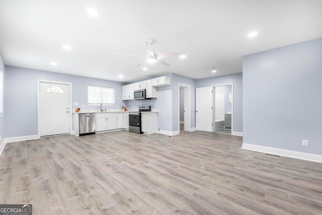 unfurnished living room with ceiling fan and light hardwood / wood-style flooring