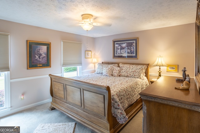 bedroom featuring ceiling fan, carpet flooring, and a textured ceiling