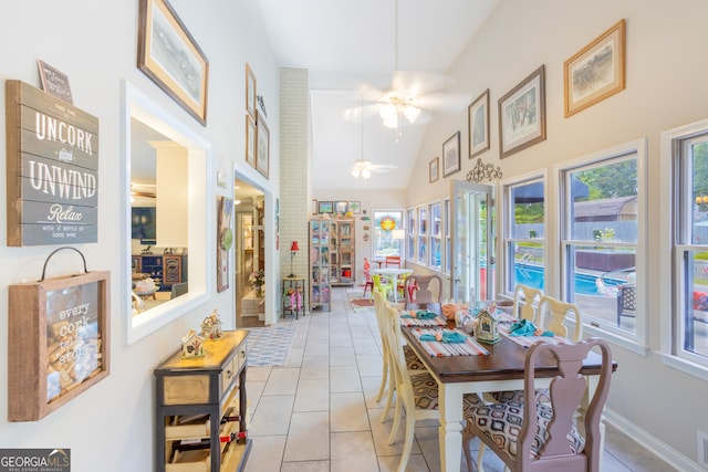 dining room featuring ceiling fan, light tile patterned floors, and high vaulted ceiling