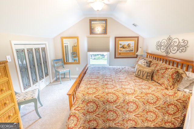 carpeted bedroom with a closet, vaulted ceiling, and ceiling fan