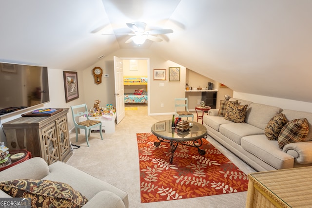 carpeted living room with ceiling fan and vaulted ceiling