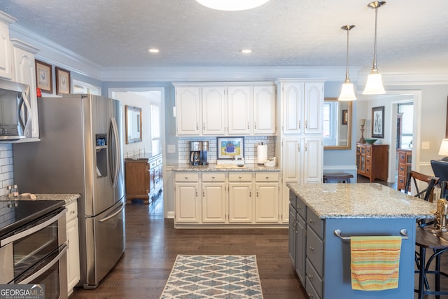 kitchen with hanging light fixtures, ornamental molding, white cabinetry, and decorative backsplash