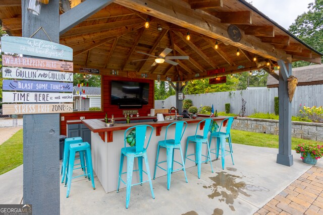 view of patio / terrace with ceiling fan, a bar, and a gazebo