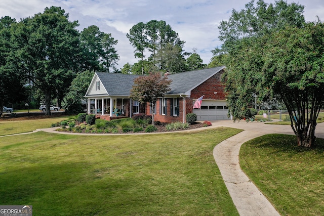 view of front of property featuring a garage, a front lawn, and covered porch