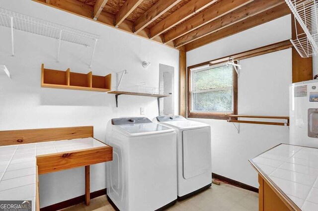 laundry room featuring water heater and independent washer and dryer