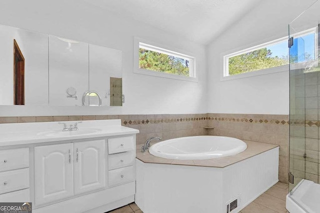 bathroom featuring vanity, lofted ceiling, independent shower and bath, and tile patterned floors