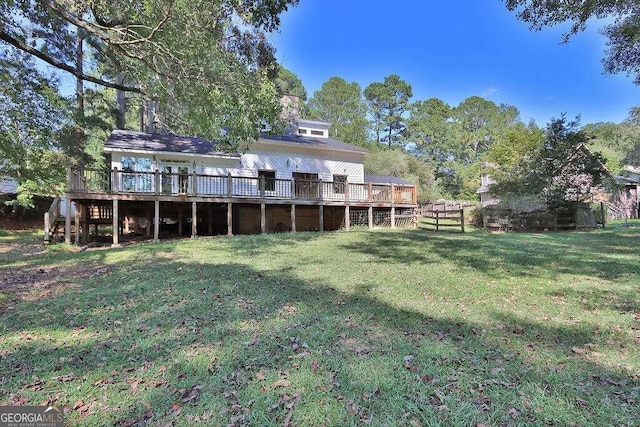 back of property with a wooden deck and a yard