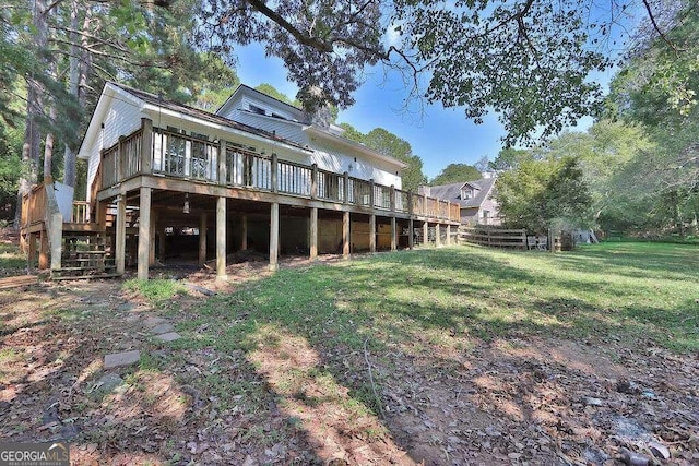 rear view of property featuring a wooden deck and a lawn