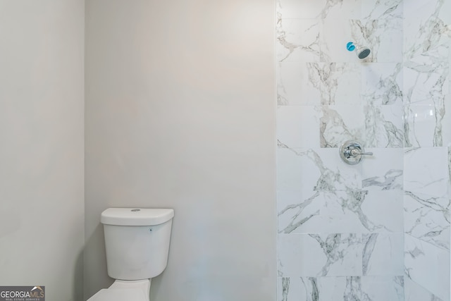 bathroom with toilet and a tile shower