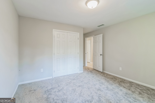 unfurnished bedroom featuring carpet floors and a closet