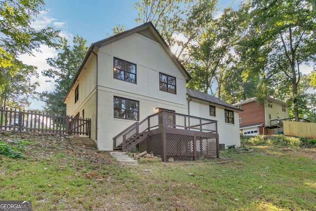 rear view of house with a deck and a yard