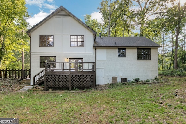 back of property featuring a deck and a yard