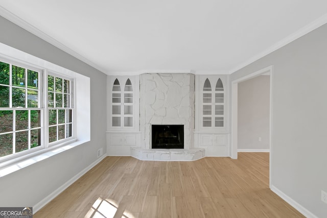 unfurnished living room with light wood-type flooring, a fireplace, and a wealth of natural light