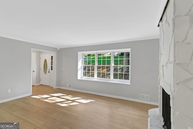 unfurnished living room featuring light wood-type flooring, crown molding, and a premium fireplace