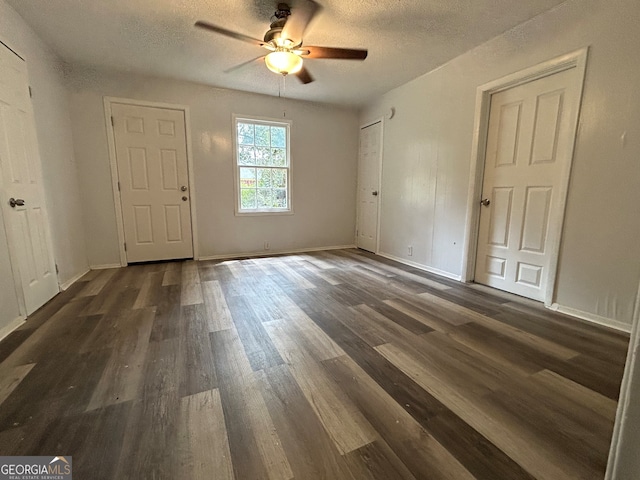 interior space featuring ceiling fan, a textured ceiling, and dark hardwood / wood-style flooring