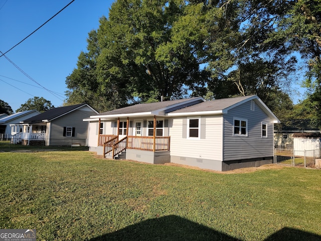 back of property with a porch and a lawn