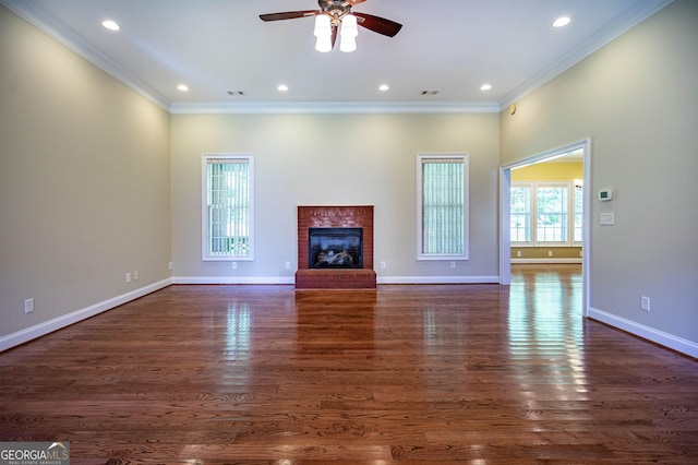 unfurnished living room featuring ornamental molding, a brick fireplace, ceiling fan, and dark wood-type flooring