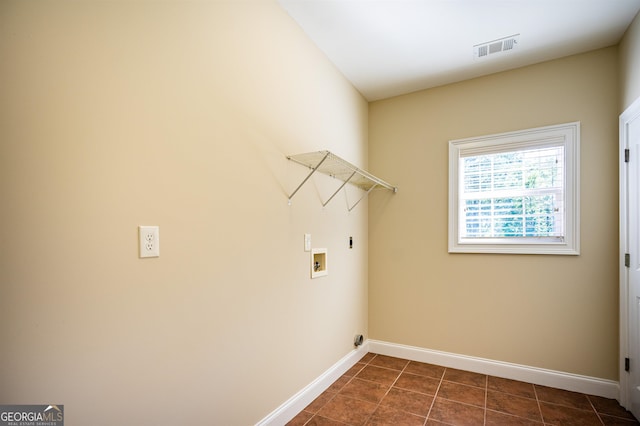 clothes washing area featuring washer hookup, dark tile patterned flooring, and electric dryer hookup