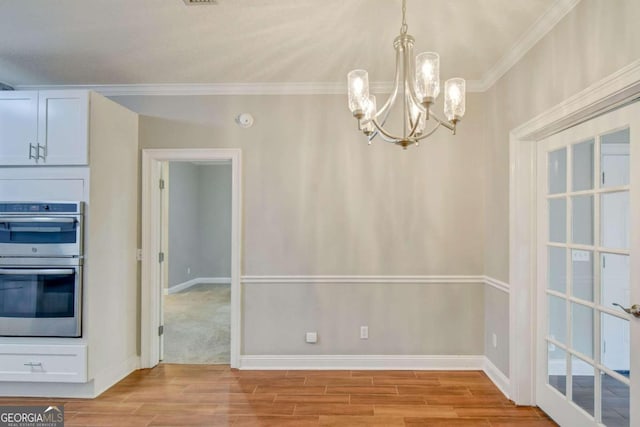 unfurnished dining area featuring ornamental molding, wood finish floors, and baseboards